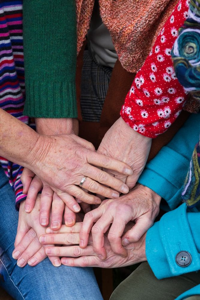 Manos de distintas edades unidas con respeto