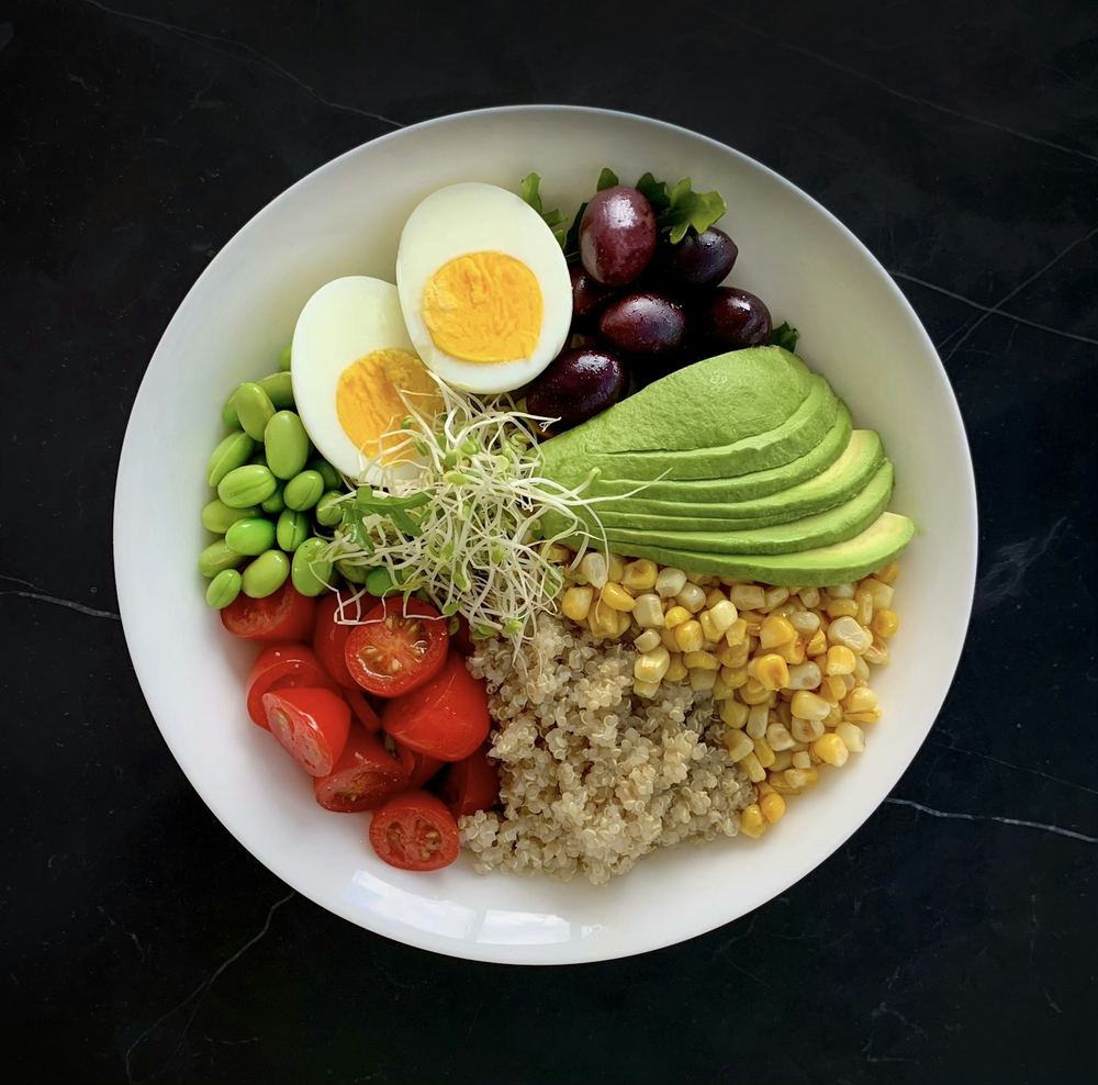 Tazón con huevo cocido, edamame, aguacate y quinoa