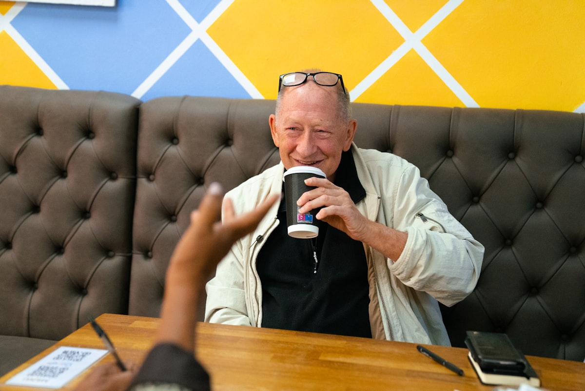 Hombre mayor disfrutando un café con una sonrisa