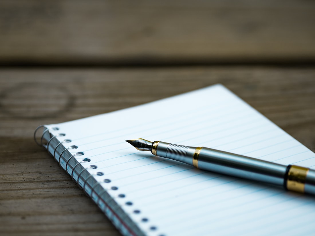 Pluma sobre un cuaderno, escribiendo una lista