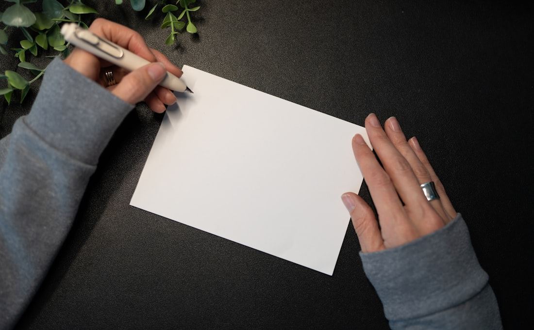 Manos escribiendo con calma sobre una tarjeta en blanco