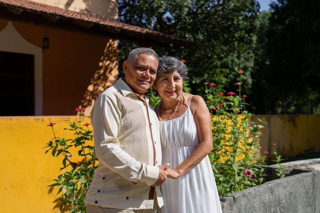 Pareja mayor sonriente y abrazada afuera de su casa