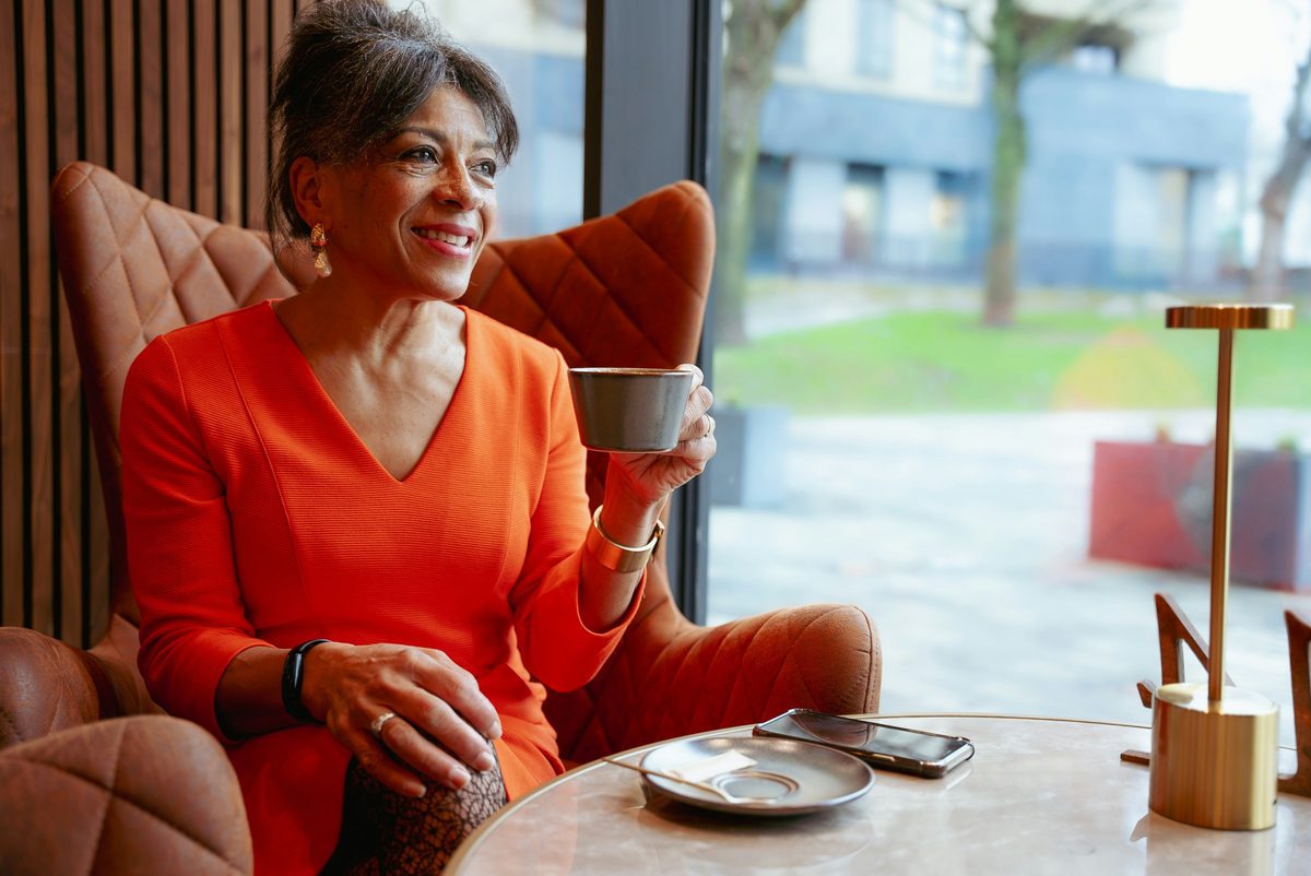 Mujer mayor disfrutando de un café con calidez