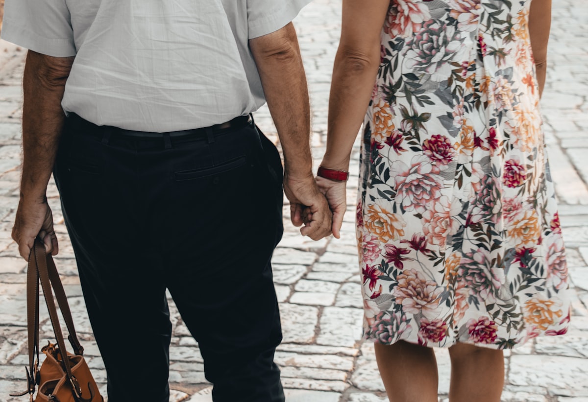 Dos personas mayores tomadas de la mano, con calidez y confianza