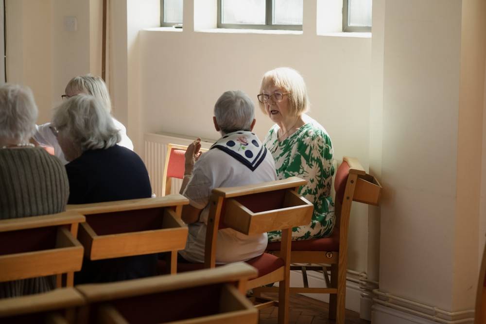 Grupo de personas mayores conversando alrededor de una mesa