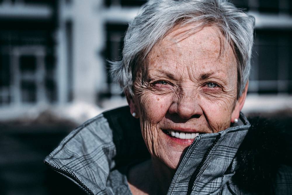 Mujer mayor sonriendo con calidez, retrato cercano