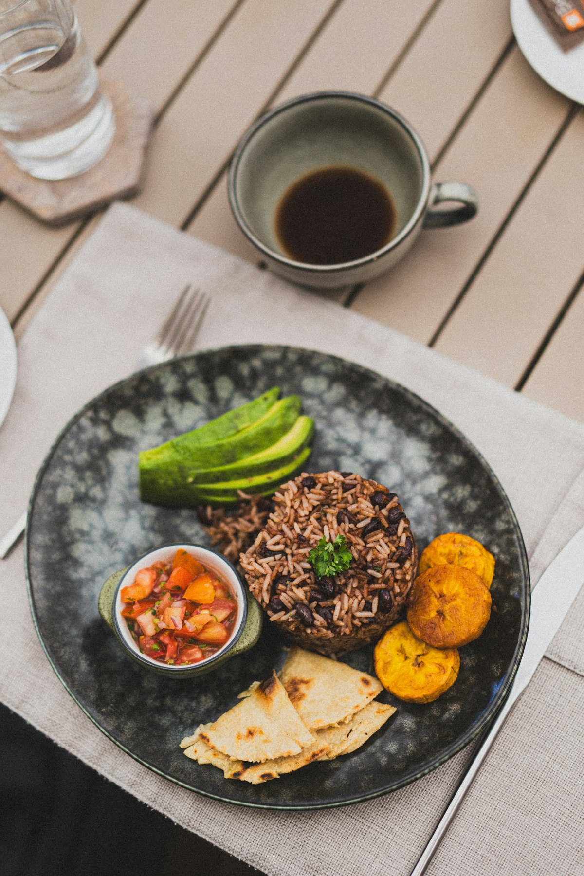 Plato casero con frijoles, aguacate, salsa fresca, tortilla y plátano