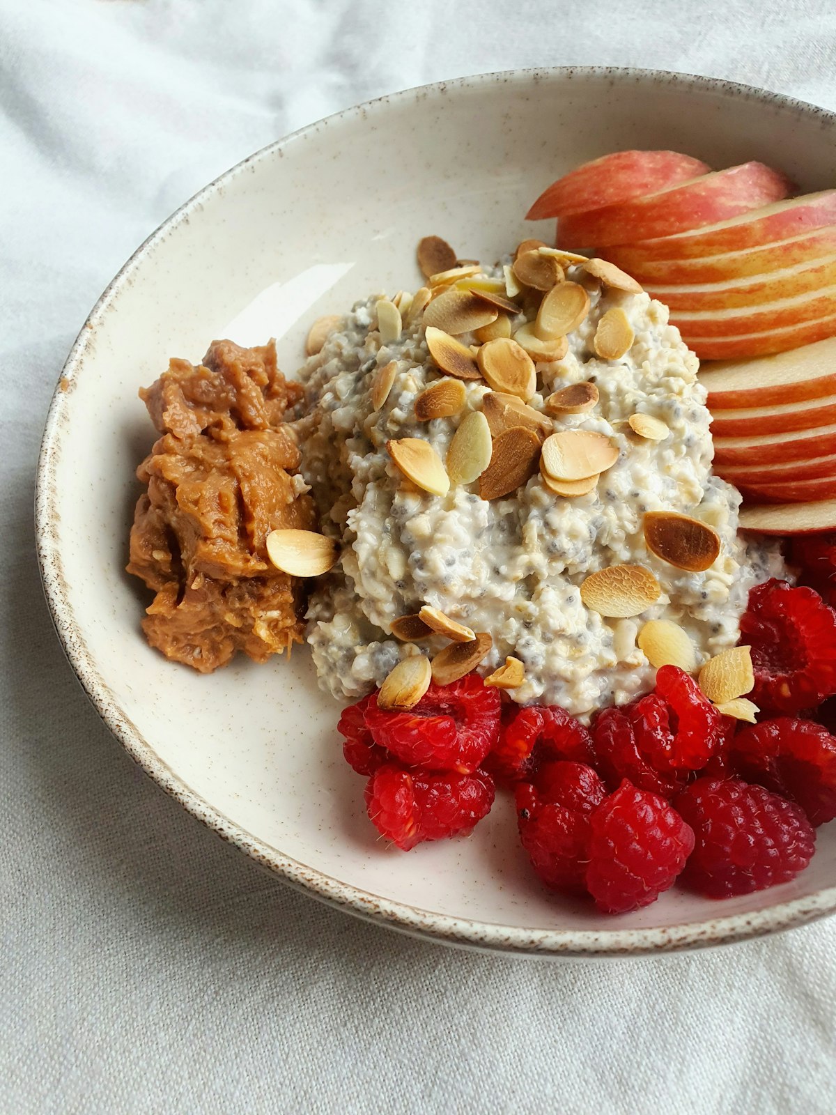 Tazón de avena con fruta fresca, frutos rojos y semillas
