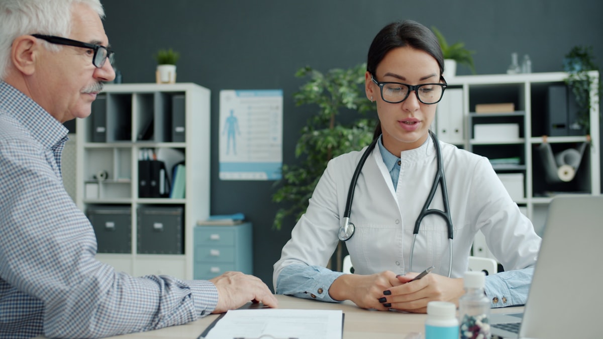 Médica conversando con un paciente mayor con calidez